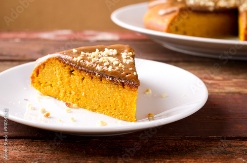 Pumpkin cake with caramel and peanuts on wooden table
