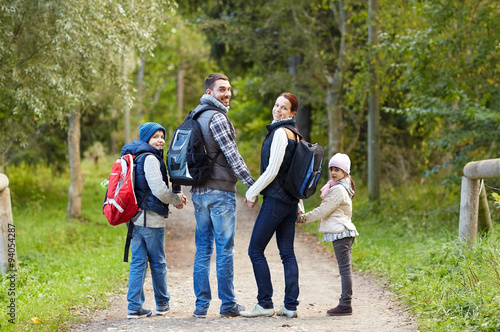 happy family with backpacks hiking walking