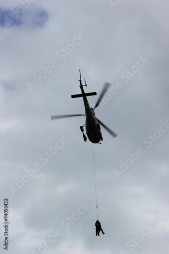 Menschen werden mittels Taubergung (Seilbergung) von einem Hubschrauber gerettet