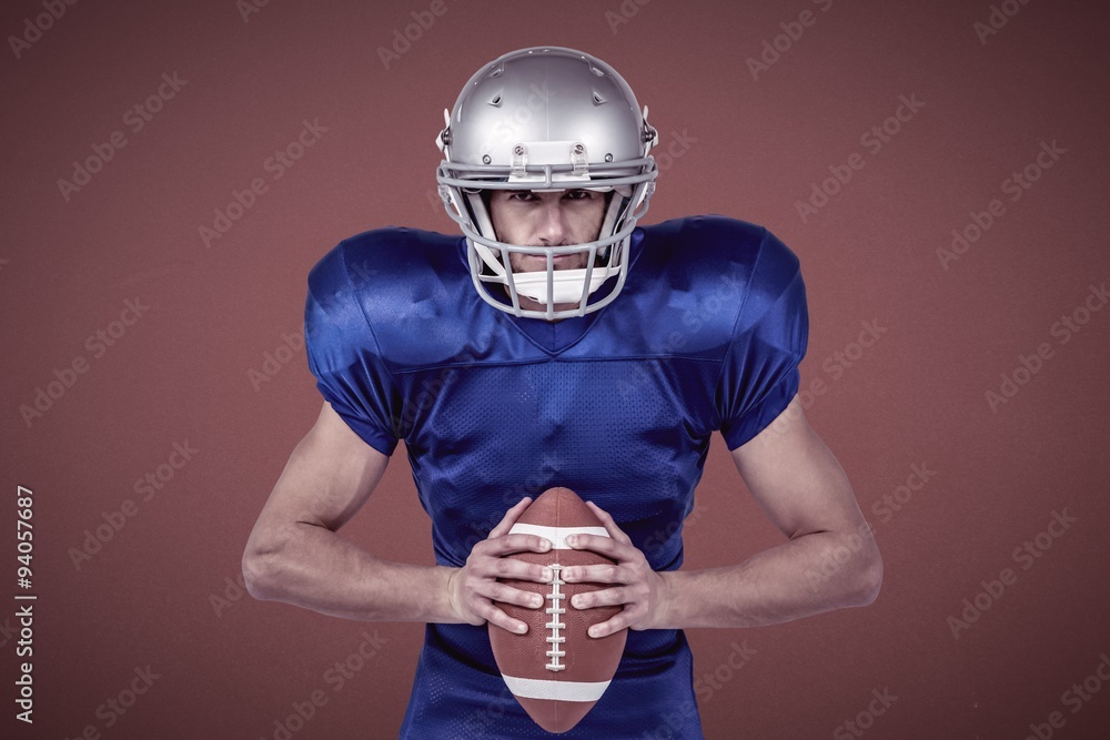 Determined american football player holding ball