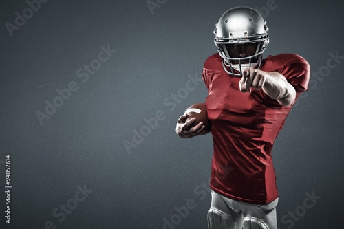 American football player pointing camera holding ball