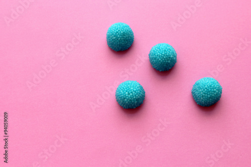 Blue candy on pink background - still life