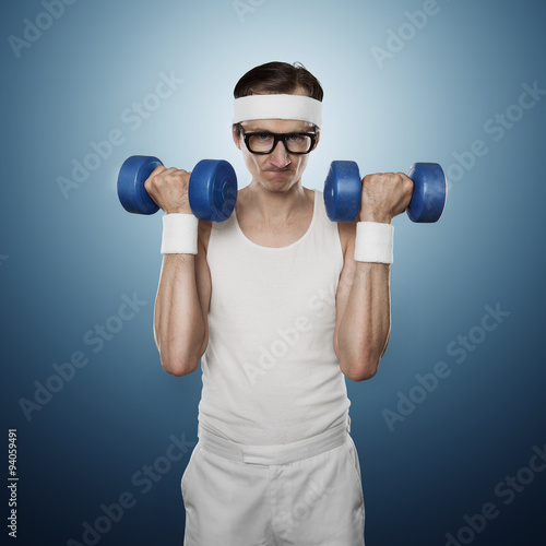 Funny sport nerd lifting weights isolated on blue background