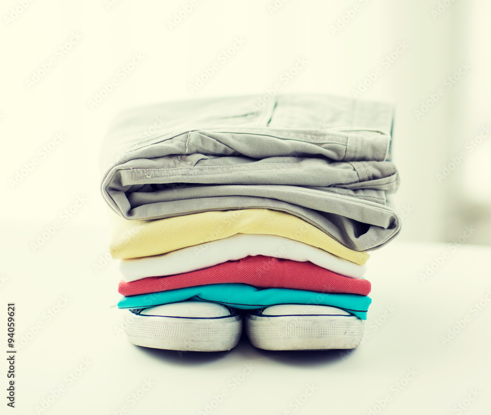 close up of folded shirts and boots on table close up of folded shirts and boots on table