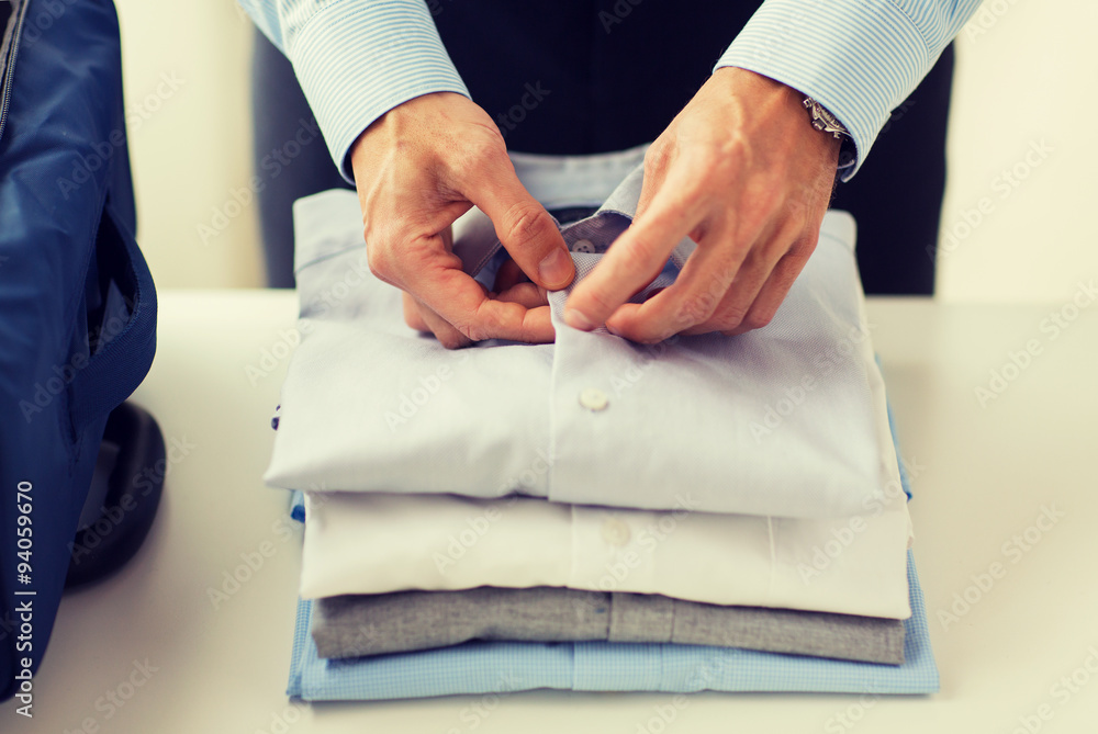 businessman packing clothes into travel bag