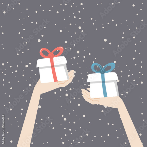 Hands are holding christmas presents with red and blue ribbons on the snowing background.