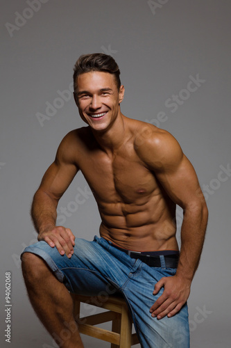 Happy Fit Man Sitting On A Wooden Stool