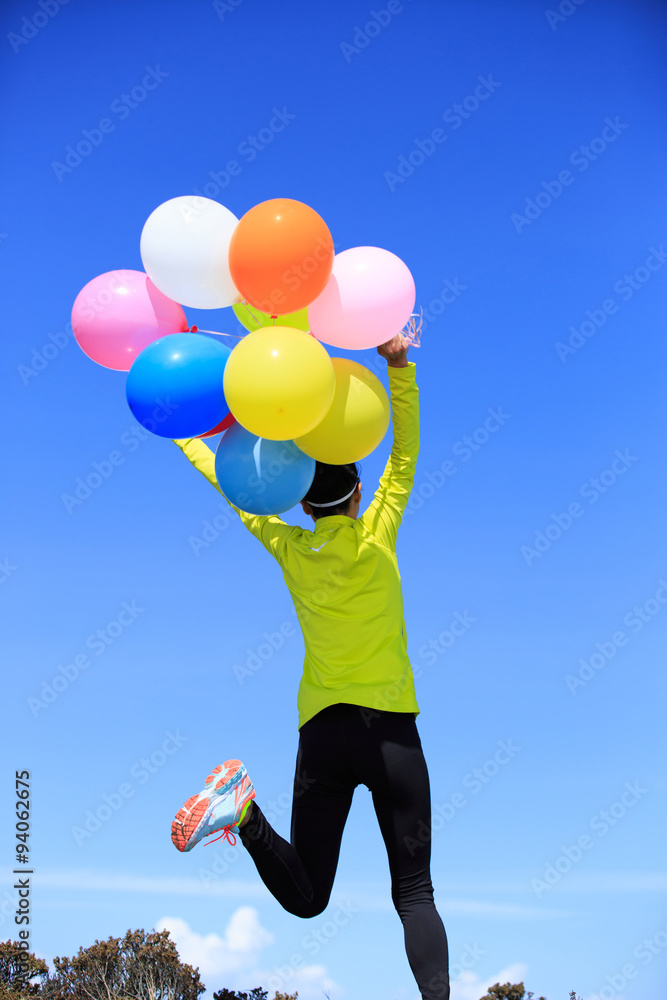 cheering young woman running on mountain peak with colorful bal cheering young woman running on mountain peak with colorful bal