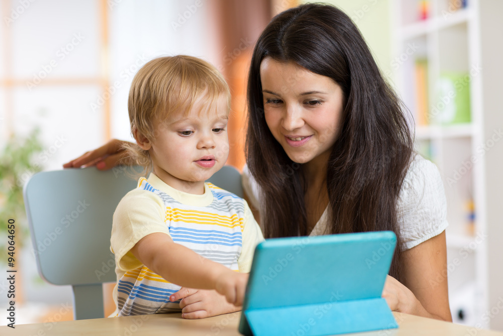 Mother reads a fairy tale to her son from a digital tablet pc Mother reads a fairy tale to her son from a digital tablet pc