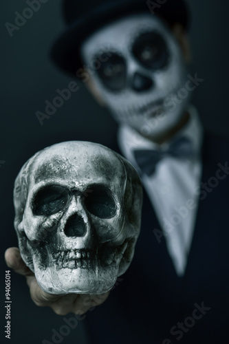 man with mexican calaveras makeup showing a skull