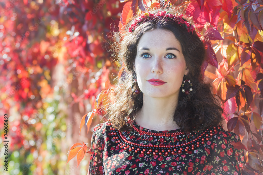 Portrait of fairy autumn girl with red fall wreath at red floral Portrait of fairy autumn girl with red fall wreath at red floral