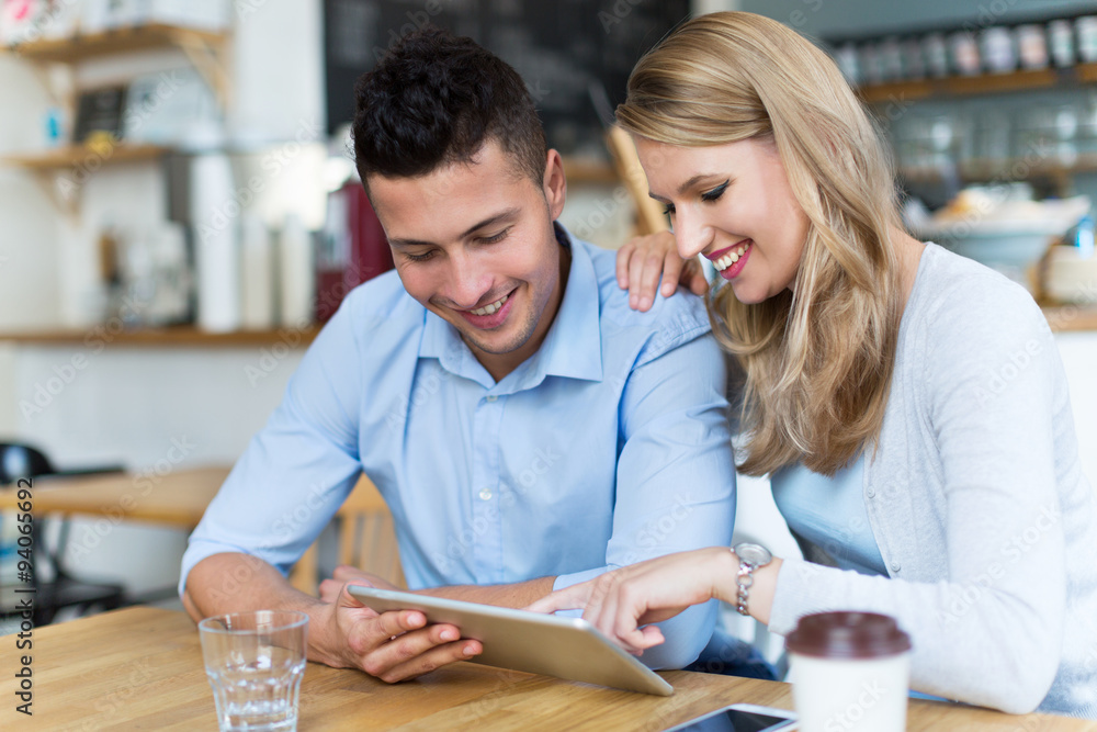 Couple using digital tablet in cafe
Couple using digital tablet in cafe