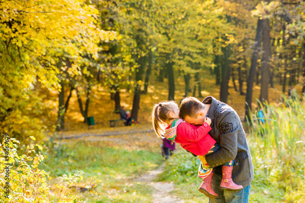 Fototapeta premium Father and daughter playing outdoors in the park in th sunny autumn day. 