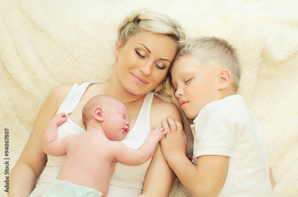 Mother with two children sleeping together on bed at home, eldes Mother with two children sleeping together on bed at home, eldes