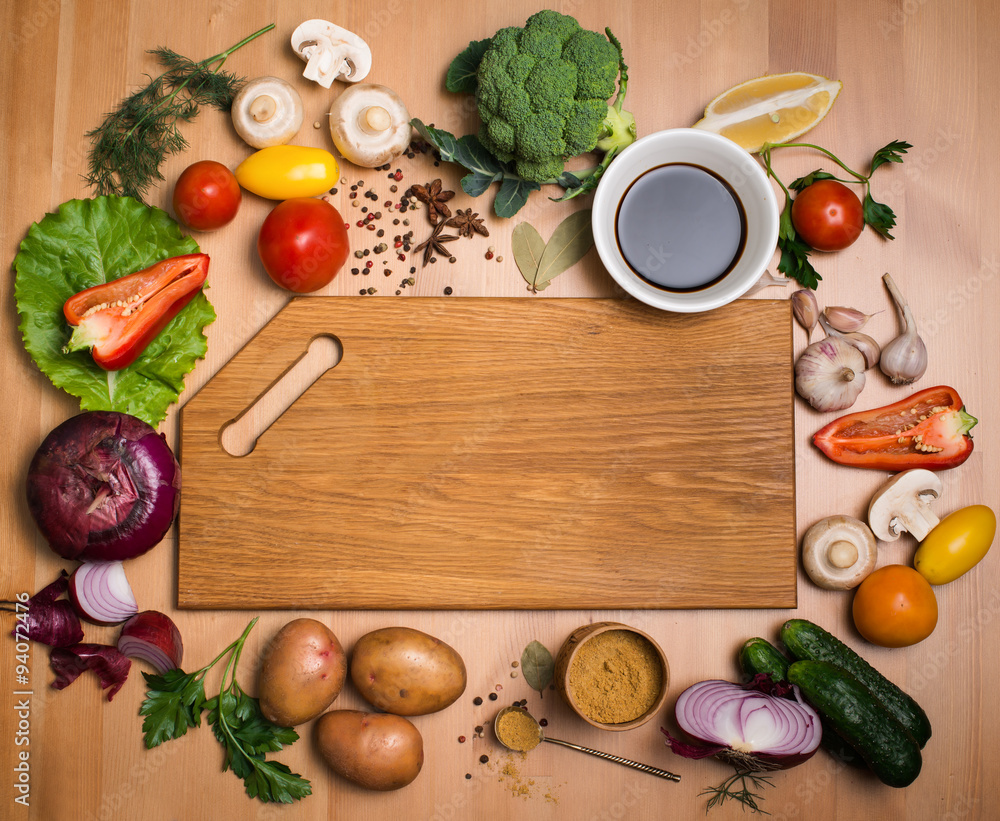 Various vegetables and spices and empty wooden cutting board. Various vegetables and spices and empty wooden cutting board.