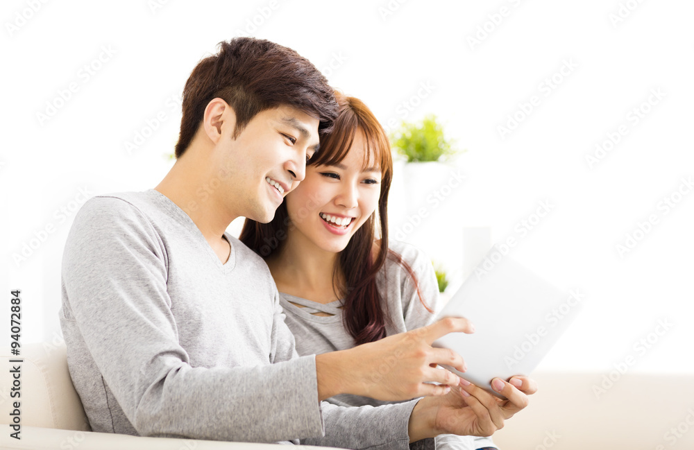 happy Couple Looking at tablet In living room happy Couple Looking at tablet In living room