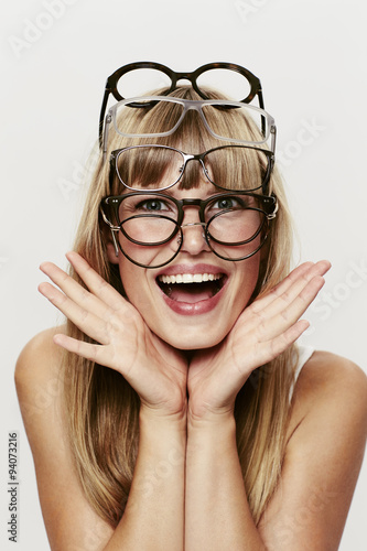 Young blond student posing in many spectacles