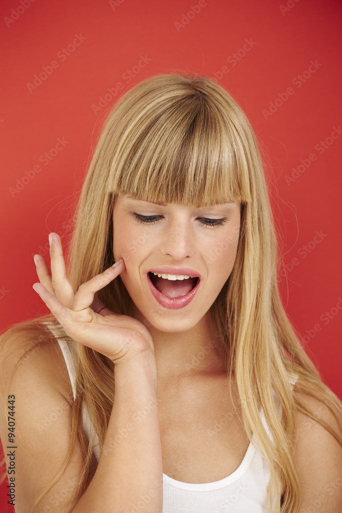 Beautiful woman looking down in red studio Beautiful woman looking down in red studio