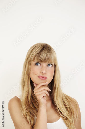 Young woman thinking in studio