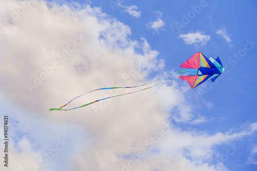 Rainbow kite flyes in the blue sky