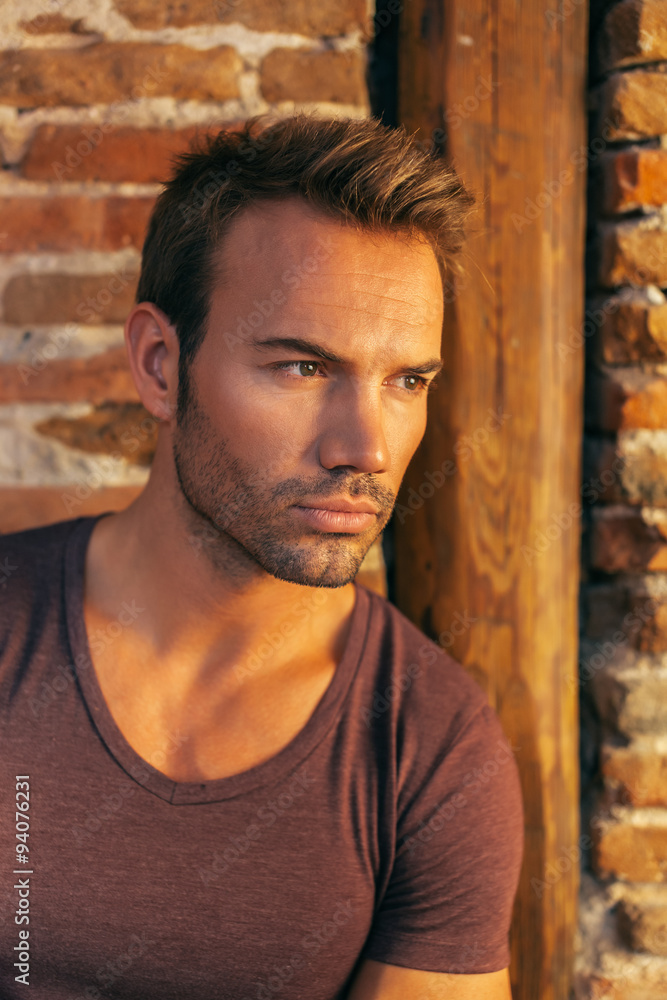 Pensive Handsome Man Lying on a Brick Wall Pensive Handsome Man Lying on a Brick Wall