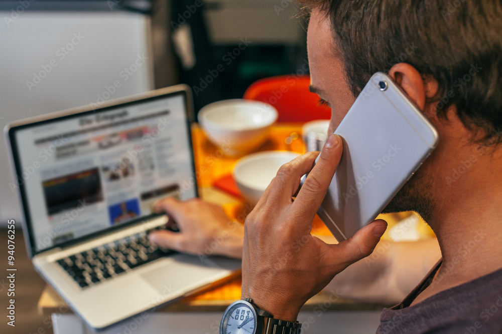 © VICTOR TORRES - Man Working at Home with a Laptop Checking the Online News