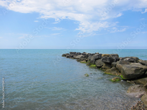 A pile of stones stretches out into the sea