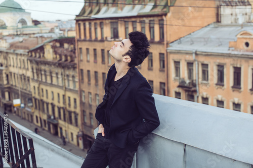 Fashion businessman on a rooftop in the center of the city