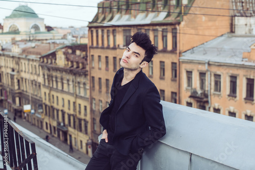 Fashion businessman on a rooftop in the center of the city