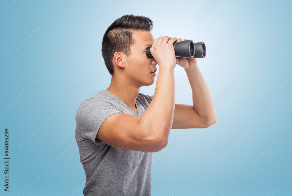handsome young asian man looking through a binoculars handsome young asian man looking through a binoculars