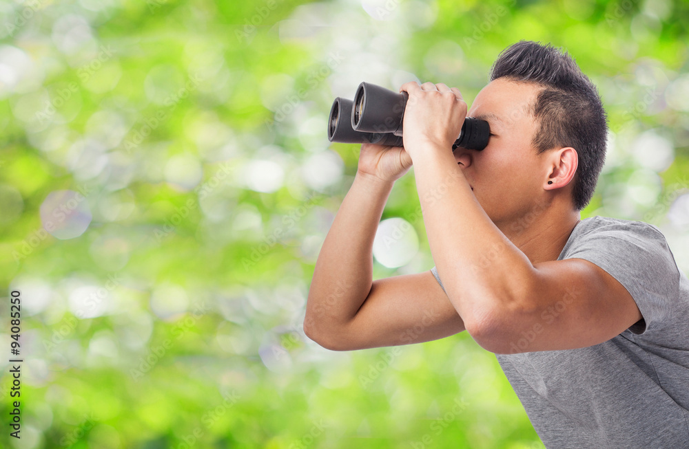handsome young asian man looking through a binoculars