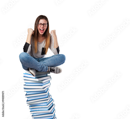 young woman happy sitting on a books pile