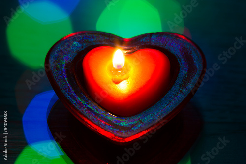 burning tea candle in the shape of a heart photo