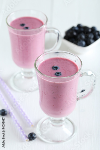 Fresh blueberry smoothie in the glasses on white wooden backgrou