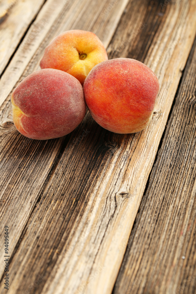 Ripe peaches fruit on a brown wooden background Ripe peaches fruit on a brown wooden background