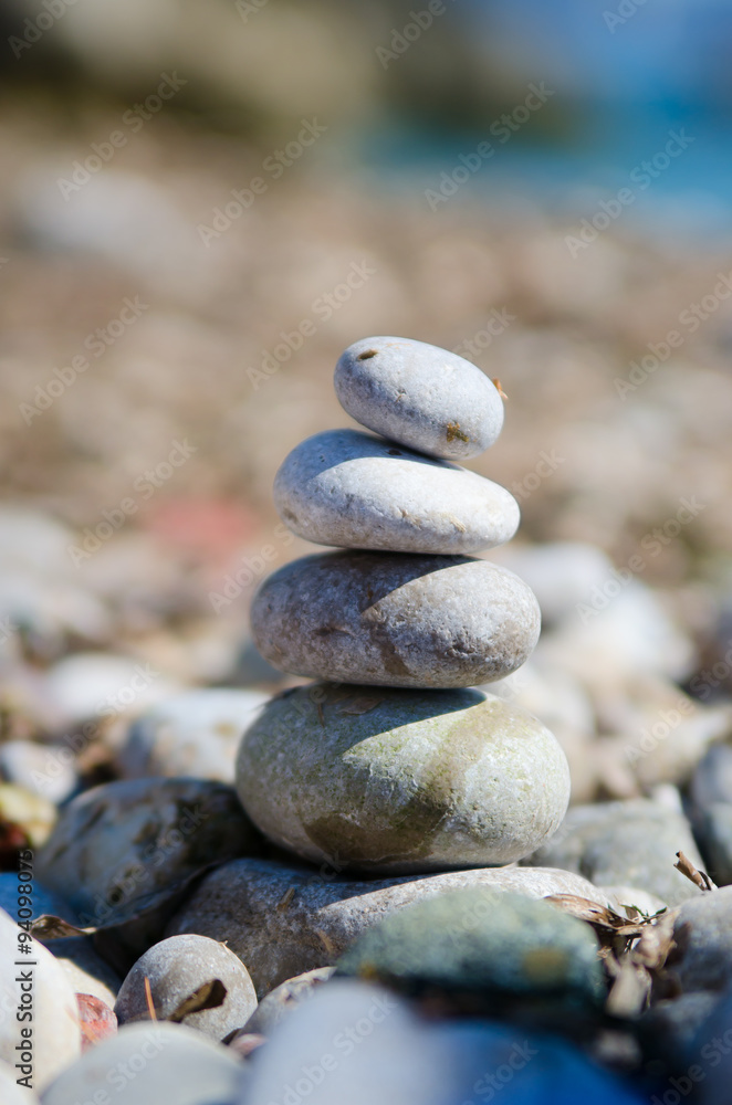 Close-up shot of natural stones stacked on stones. The rocks are illuminated on the right side, creating a distinct drop shadow. The background is boke. Close-up shot of natural stones stacked on stones. The rocks are illuminated on the right side, creating a distinct drop shadow. The background is boke.