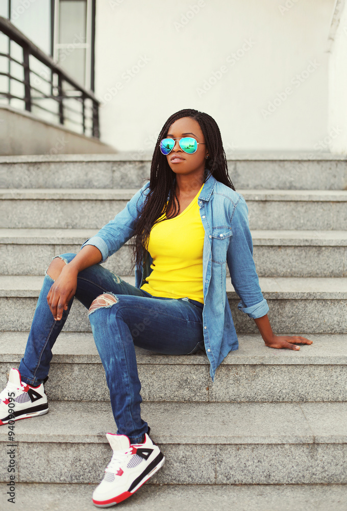 Fashion beautiful young african woman wearing a sunglasses and j