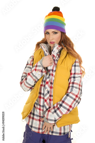 woman with red hair in yellow vest and hat look