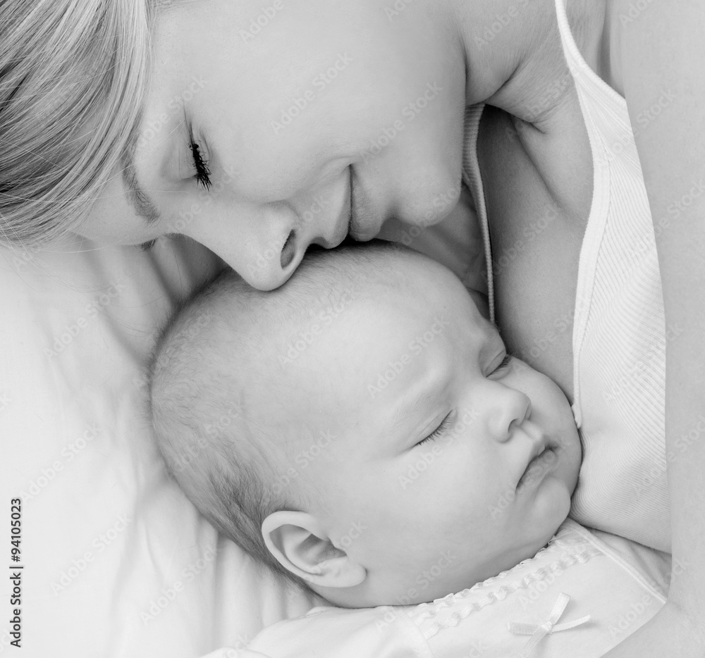 Young mother and her baby, sleeping in bed. Mother and baby. Hap Young mother and her baby, sleeping in bed. Mother and baby. Hap
