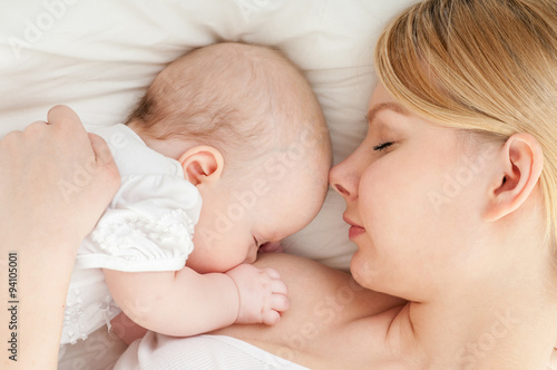 Young mother breastfeeds her baby. Breast-feeding.