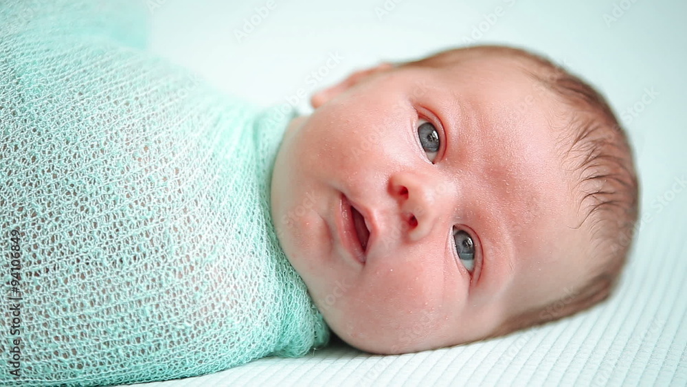 Adorable blue-eyed newborn baby lying and looking around in Adorable blue-eyed newborn baby lying and looking around in