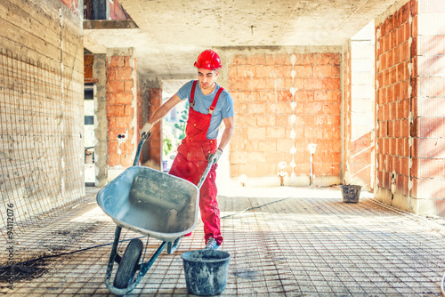 Valokuva worker with empty wheelbarrow on construction site