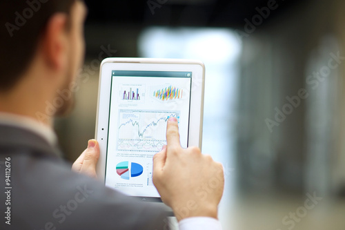 Obraz na płótnie Business person analyzing financial statistics displayed on the tablet screen w salonie