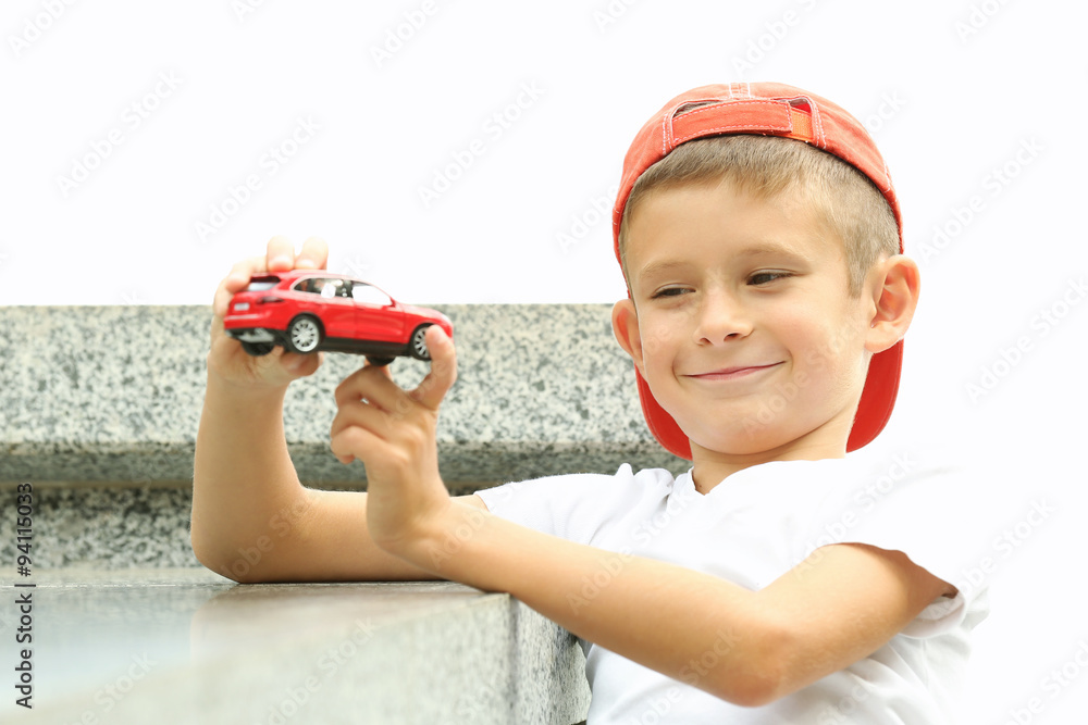 Obraz premium Little boy playing with toy car outside