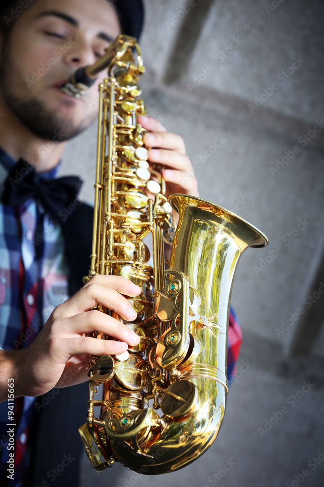 Obraz premium Saxophonist plays jazz outdoors, close up