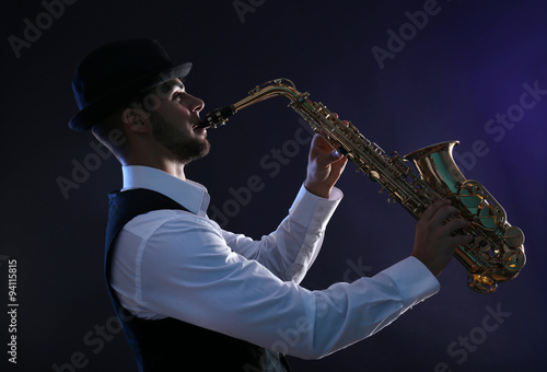 Photography Elegant saxophonist plays jazz on dark background