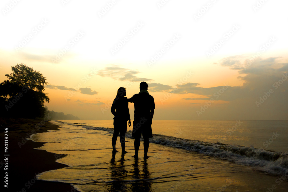 Stock Photo:.Silhouettes of romantic couple on tropical beach at Stock Photo:.Silhouettes of romantic couple on tropical beach at