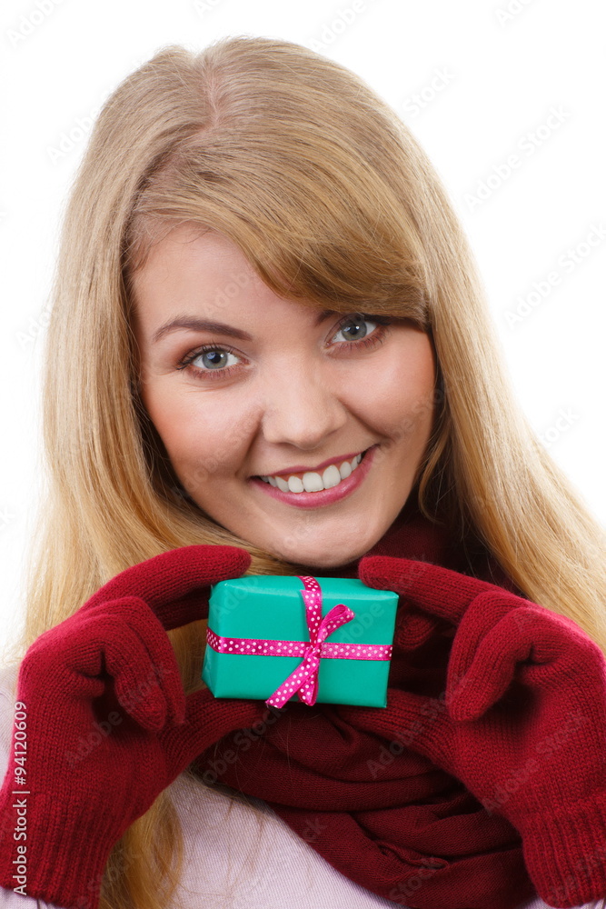 Smiling woman in woolen gloves with wrapped gift for Christmas or other celebration Smiling woman in woolen gloves with wrapped gift for Christmas or other celebration