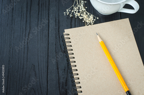 Note book and pencil and coffee time on wooden