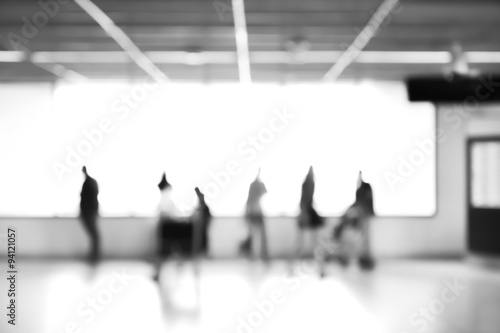 Blur abstract background of people inside airport terminal, monochrome effect